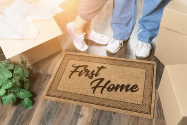 First-time home buyers stepping onto a First Home doormat in Airdrie